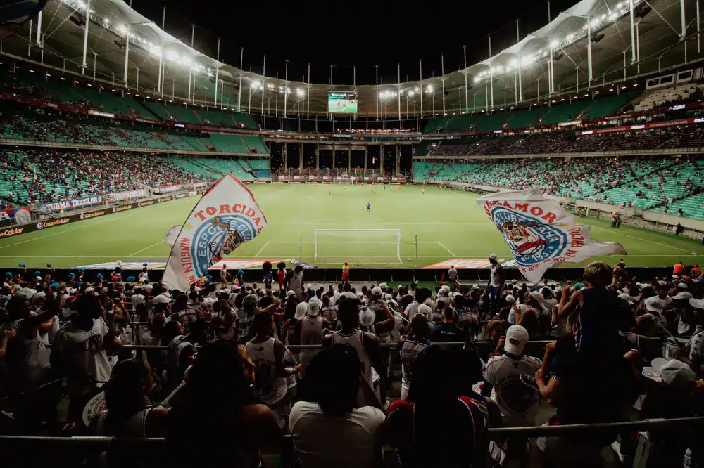 Huge crowd cheering at an esports stadium with vibrant lighting