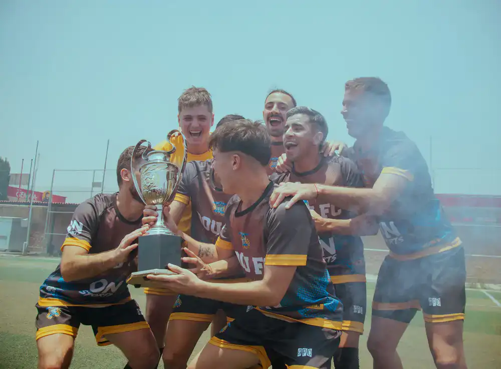 Winning team lifting the trophy amid pyrotechnics