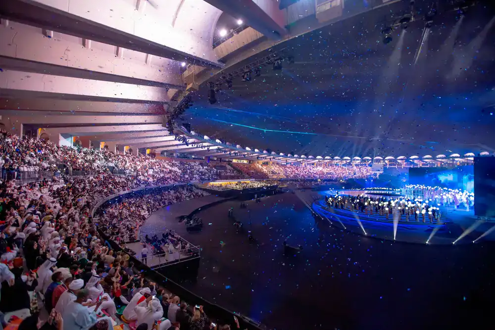 Massive esports arena stage with vibrant blue and magenta lighting